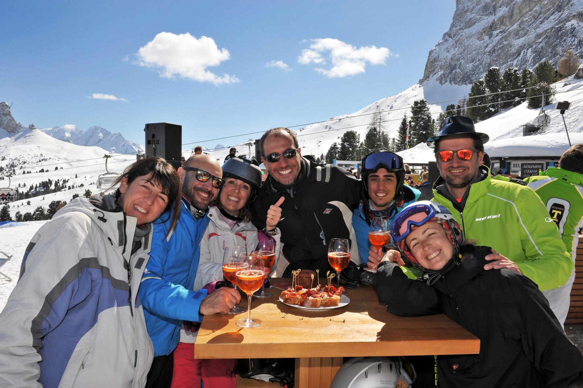 Group of friends around a table drinking Aperol Spritzes and snacking on bread and cheese