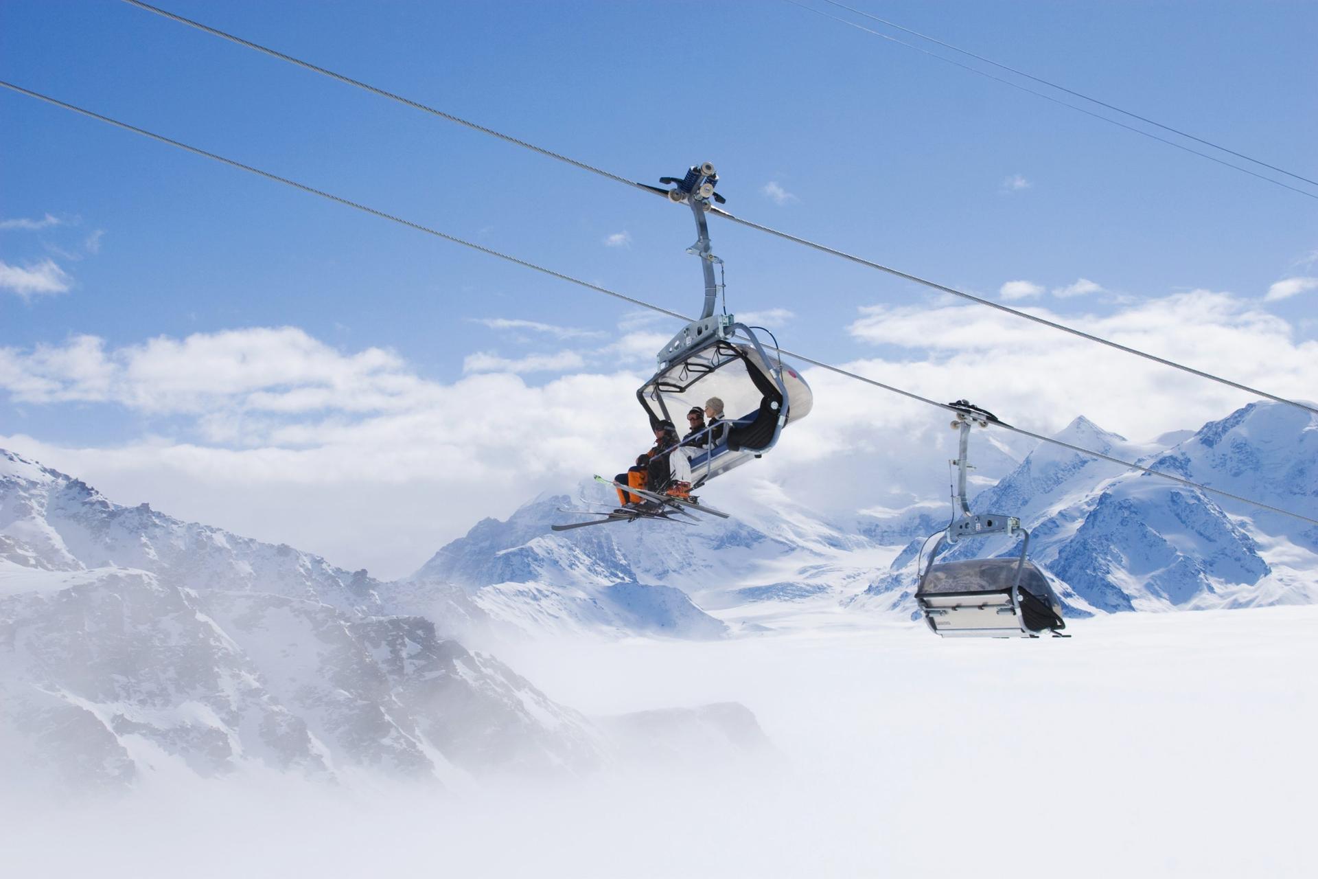 Friends on a chairlift with mountains in the background